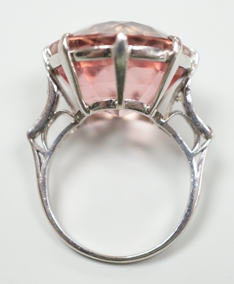 A white metal and circular cut pink topaz set dress ring, with three stone graduated diamond set shoulders, size I/J, gross weight 6.6 grams